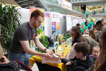 Children collecting stickers from the Earlham Institute stand at Norwich Science Festival 2024