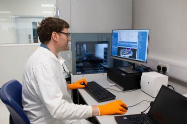 Senior Scientist Tom Brabbs using the TECAN automated liquid handling technology