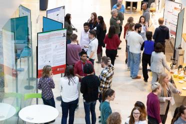 Staff and students networking at EI during a conference poster session