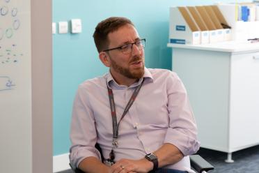 Prof Neil Hall sitting talking to someone to the side off camera