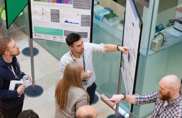 Students networking during a poster session at last year's student symposium